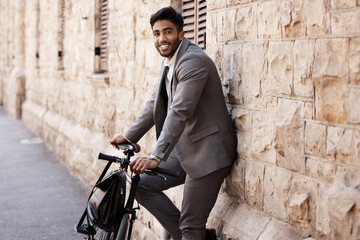 Wall Mural - Bicycle, portrait and happy business man in city for carbon neutral, sustainable and transport. Bike, commute and Indian male person on cycling break, smile and relax while traveling in India