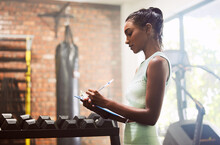 Exercise, Personal Trainer And Woman In A Gym, Inventory And Checklist For Equipment, Schedule And Hygiene Inspection. Female Person, Entrepreneur Or Athlete With Documents, Feedback And Training