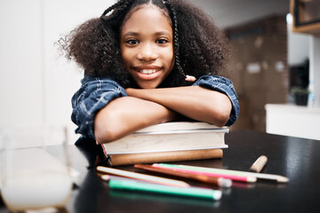 Child, school books and happy for education, learning and development at a table in a house. Face portrait of an african girl kid or student with a smile, knowledge and happiness while studying