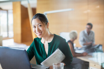 Wall Mural - Businesswoman smiling with laptop in office