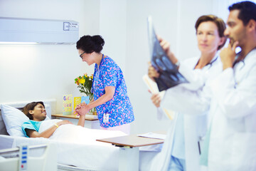 Wall Mural - Nurse holding hands with patient in hospital room