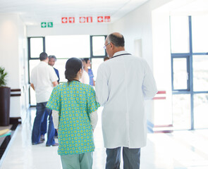 Wall Mural - Doctor and nurse walking in hospital corridor