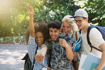 Wall Mural - Enthusiastic college students taking selfie in park