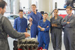 © KOTO - Mechanic and students discussing car engine in auto repair shop