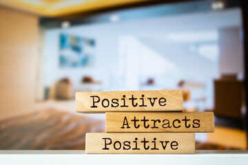 Wooden blocks with words 'Positive Attracts Positive'