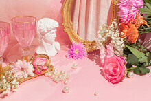 Spring Summer Creative Layout With David Head Statue, Vintage Golden Frame Mirror, Pink Wine Glasses, Flowers, Pearls On Pastel Pink Background. 80s, 90s Retro Romantic Aesthetic Love Concept. 