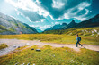© Michael - Young sportive woman walks along scenic Dolomites high trail in the afternoon. Tre Cime, Dolomites, South Tirol, Italy, Europe.