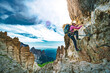 Young athletic woman hikes in via ferrata in the evening. Tre Cime, Dolomites, South Tirol, Italy, Europe.