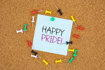 Poster - Happy pride text on light blue post-it paper pinned on bulletin cork board surrounding by multi color pins. This message can be used in business concept about happy pride.