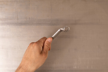Poster -  Metal wrench in male hand isolated on white