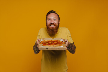 Sticker - Happy man in t-shirt smiling and holding pizza while standing isolated