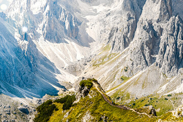 Wall Mural - Athletic woman walks on super epic view point with Cadini group in the morning. Tre Cime, Dolomites, South Tirol, Italy, Europe.