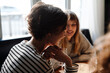 © Drobot Dean - Group of cheerful friends talking while dining in restaurant