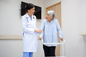 Female doctor supporting an elderly female patient holding a cane.