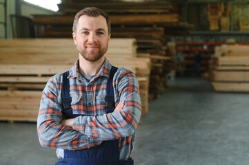 carpenter in the wood warehouse selects plank for furniture making in the carpentry workshop