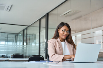 busy professional business woman employee working looking at computer typing in office. young africa