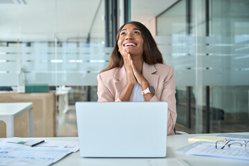 Motivated professional young African American business woman executive feeling happy about financial work results, job promotion or corporate goals achievement sitting with laptop in office.