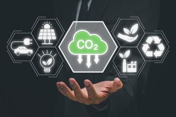 Reduce CO2 emission concept, Person hand holding CO2 icon on virtual screen, Sustainable development and green business based on renewable energy, electric transport.