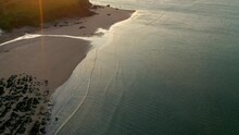 Tilting Drone Shot Revealing Bigbury Beach At Golden Sunrise