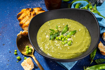 Homemade green pea cream soup, green gazpacho cold soup with peas decor and croutons, tasty vegan food, diet dinner recipe