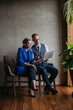 © Halfpoint - Two colleagues sitting near window and working on notebook in modern office full of plants.