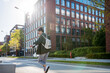 © Halfpoint - Rear view of young happy woman in city.