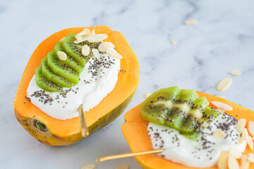 Wall Mural - Yogurt papaya boat with kiwi, chia seeds and almonds. Healthy summer food.