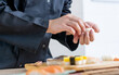 © Ann Rodchua - Close up and selective focus on chef hand putting fish on rice ball, cooking and making sushi, Japanese traditional street food. Restaurant, Hotel Concept.