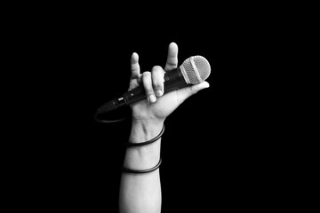 microphone in hand of singer raised his hand all the way up in live concert. hand sign mean love, love to sing concept