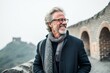 © Anne Schaum - Portrait of happy senior man in eyeglasses on the great wall background
