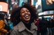 © Leon Waltz - Cheerful african american woman laughing while standing in Times Square in New York