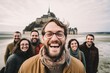 © Anne Schaum - Group portrait photography of a grinning man in his 30s that is smiling with friends at the Mont Saint-Michel in Normandy France . Generative AI