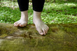 © Fotema - Woman is walking barefoot on huge log tree trunk in forest area. Nature connection concept.