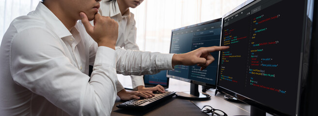 Wall Mural - Software development team working together in office, coding script display on computer monitor. Programmer and software engineer working in tech developer company. Trailblazing