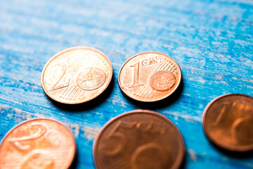 Euro coins of different countries on blue background. One, two and five cent.