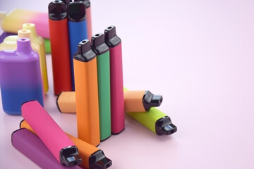 Wall Mural - Set of multicolor disposable electronic cigarettes on a pink background.