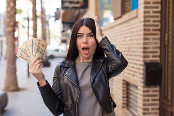 pretty young woman feeling extremely shocked and surprised. dollar banknotes concept