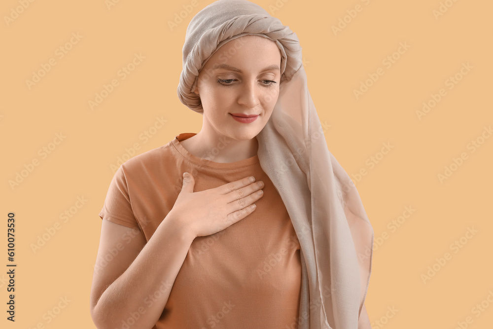Young woman after chemotherapy on beige background
