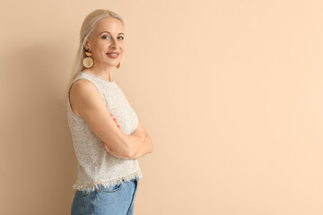 Mature blonde woman on beige background