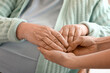 © Pixel-Shot - Senior woman with her granddaughter holding hands at home, closeup