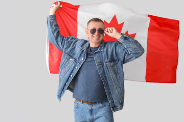 Poster - Mature man with flag of Canada on light background