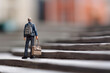 © sommersby - Miniature toy figurine of traveling businessman with big bag climbs ladder to success, created with Generative AI