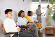 © JackF - Casual young guy sitting at hall of civil service building, waiting to speak with representative of immigration office