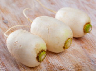 Wall Mural - Whole ripe turnip root vegetables on wooden background. Healthy nutrition concept