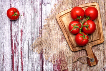 Wall Mural - Ripe, juicy, red tomatoes on a cutting board. Top view, space for drain.