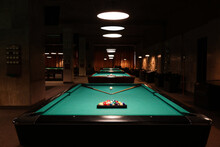 Billiard tables with balls and cues in club