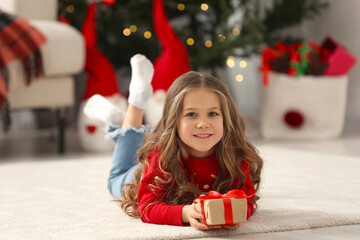 Sticker - Happy girl lying on soft carpet with Christmas gift at home