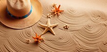 Summer Composition. Straw Hat With Starfish And Beach Accessories Over Sand.