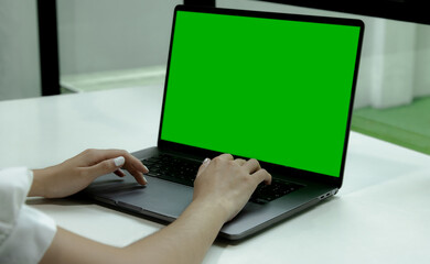 Poster - Green screen laptop computer for your copy space and text advertising. Woman using notebook empty screen.