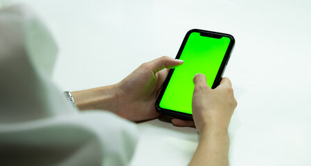 Poster - Green screen smartphone. Woman using mobile phone blank green screen vertical view for your advertising copy space and text. Technology and business.